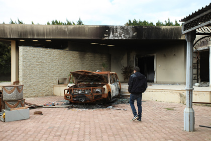 Сгоревший автомобиль и здание на территории консульства США в Бенгази