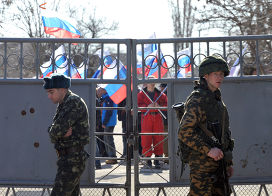Российский и украинский военные на территории военной безы в Евпатории, на заднем плане - пророссийский митинг местных жителей