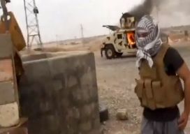 Боевик «Исламского государства Ирака и Шама» у горящего «Хаммера» иракской армии 